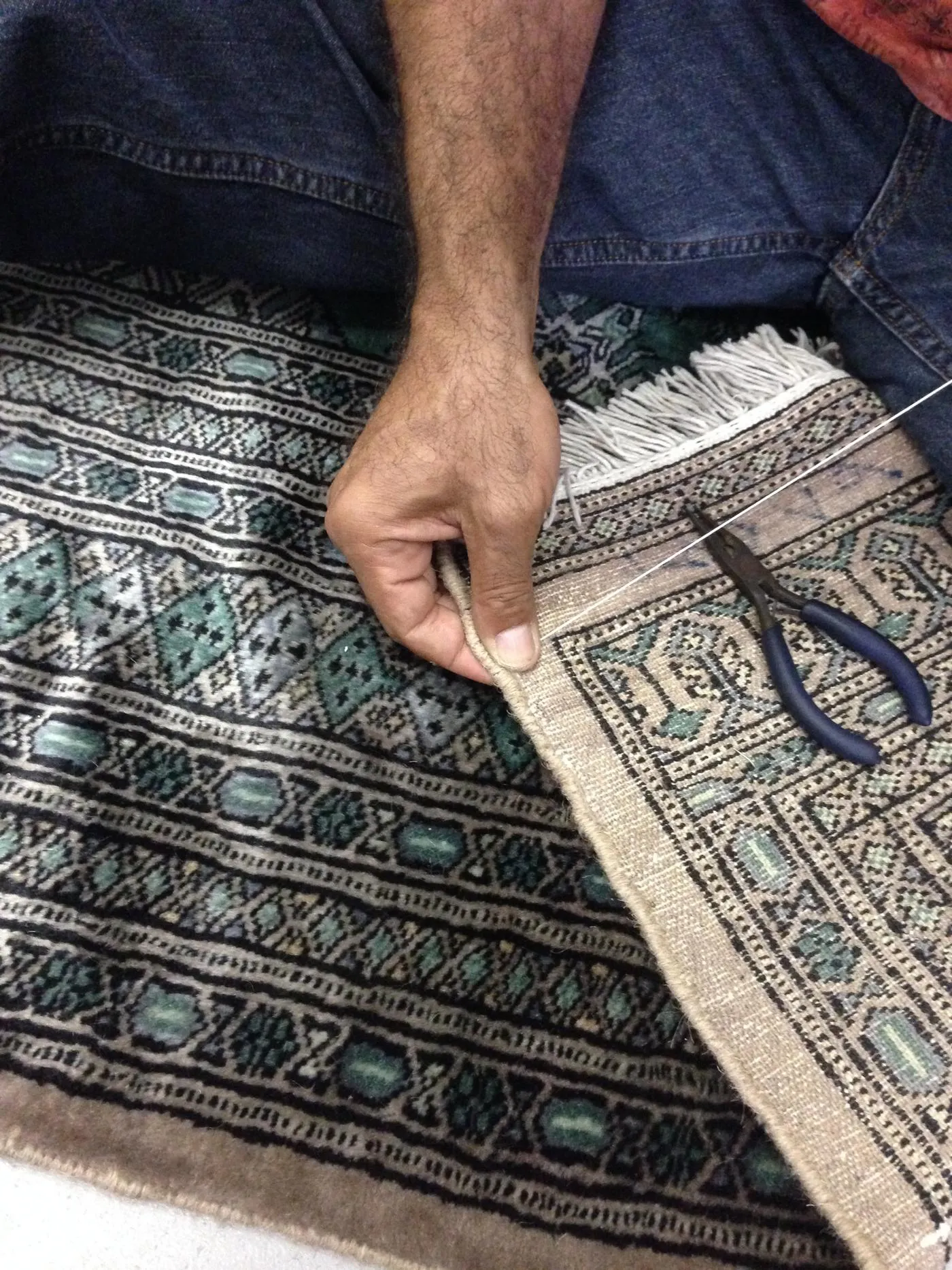 Persian rug being repaired by hand on the workbench