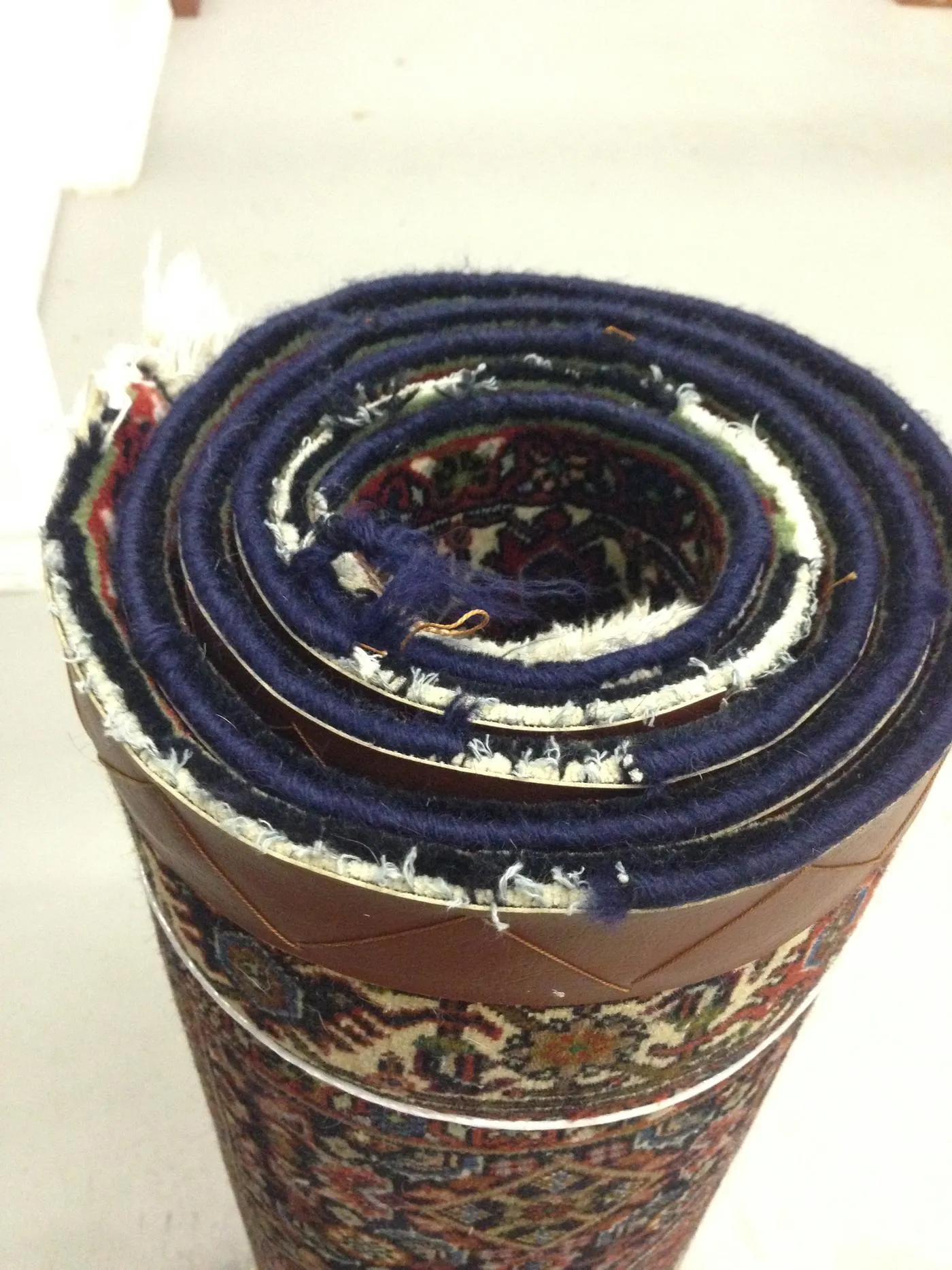 Frayed, worn side edge of a Persian rug before repair