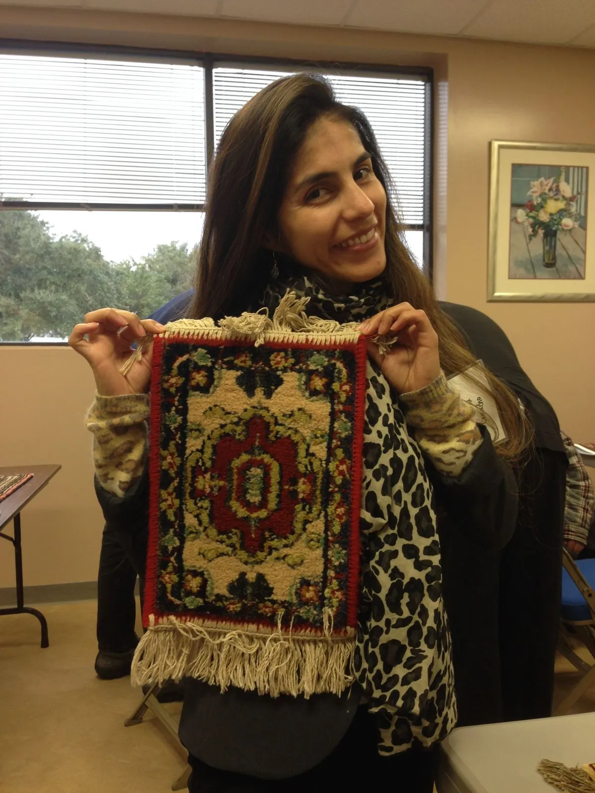 Team member holding a freshly cleaned rug, finished and ready for delivery